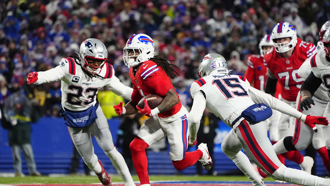 Dec 22, 2024; Orchard Park, New York, USA; Buffalo Bills running back James Cook (4) runs with the ball past New England Patriots safety Kyle Dugger (23) and New England Patriots safety Marte Mapu (15) for a touchdown during the first half at Highmark Stadium. Mandatory Credit: Gregory Fisher-Imagn Images