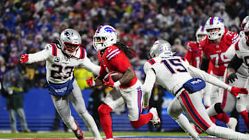 Dec 22, 2024; Orchard Park, New York, USA; Buffalo Bills running back James Cook (4) runs with the ball past New England Patriots safety Kyle Dugger (23) and New England Patriots safety Marte Mapu (15) for a touchdown during the first half at Highmark Stadium. Mandatory Credit: Gregory Fisher-Imagn Images