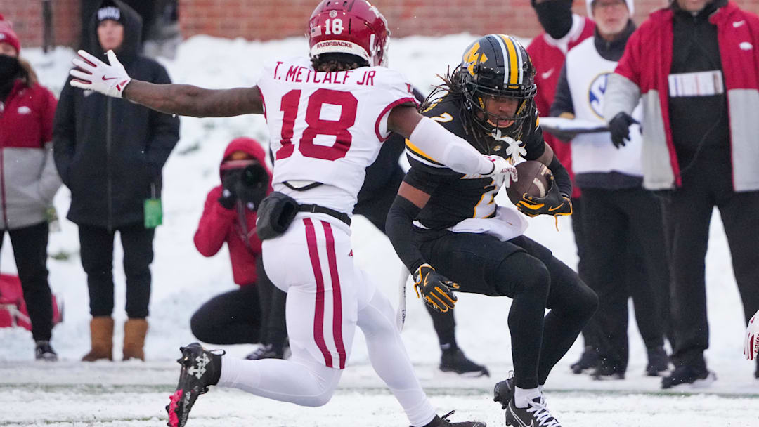 Nov 30, 2024; Columbia, Missouri, USA; Missouri Tigers wide receiver Marquis Johnson (2) runs the ball as Arkansas Razorbacks defensive back TJ Metcalf (18) attempts the tackle during the first half at Faurot Field at Memorial Stadium. Mandatory Credit: Denny Medley-Imagn Images