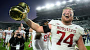 Indiana offensive lineman Bray Lynch holds The Old Brass Spittoon Trophy after the Hoosiers beat Michigan State in 2024.