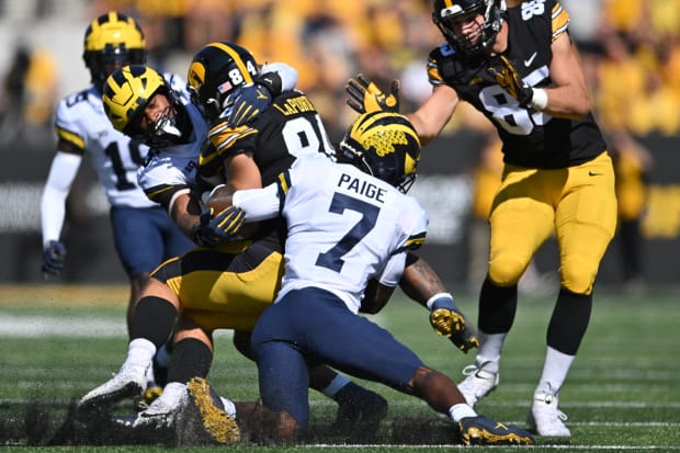 Michigan Wolverines safety Makari Paige, linebacker Junior Colston tackle Iowa's Sam LaPorta in a game vs. the Hawkeyes