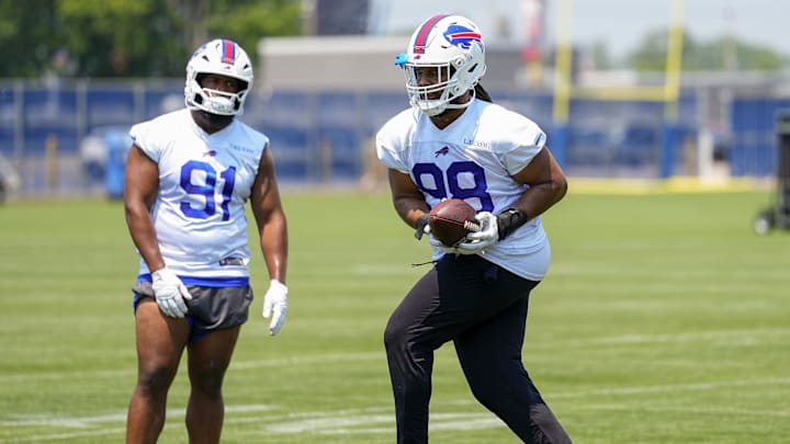Jun 11, 2025; Orchard Park, NY, USA; Buffalo Bills defensive tackle T.J. Sanders (98) makes a catch with defensive tackle Ed Oliver (91) looking on during Minicamp at Highmark Stadium. Mandatory Credit: Gregory Fisher-Imagn Images