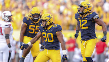 Oct 2, 2021; Morgantown, West Virginia, USA; West Virginia Mountaineers defensive lineman Akheem Mesidor (90) celebrates after a sack during the third quarter against the Texas Tech Red Raiders at Mountaineer Field at Milan Puskar Stadium. Mandatory Credit: Ben Queen-Imagn Images