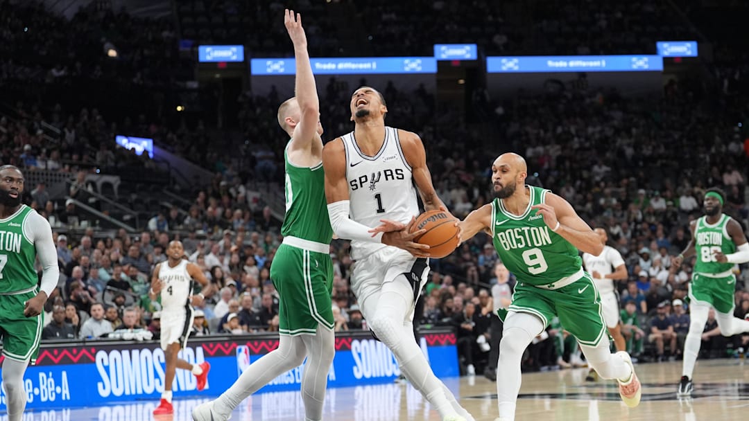 Mar 10, 2026; San Antonio, Texas, USA; San Antonio Spurs forward Victor Wembanyama (1) drives to the basket against Boston Celtics forward Sam Hauser (30) and guard Derrick White (9) in the first half at Frost Bank Center. Mandatory Credit: Daniel Dunn-Imagn Images