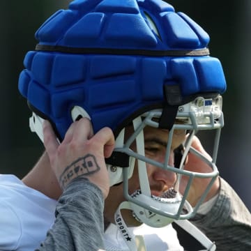 Indianapolis Colts defensive end Laiatu Latu (97) puts on his helmet as practice begins during training camp Tuesday, July 30, 2024, at Grand Park Sports Complex in Westfield.