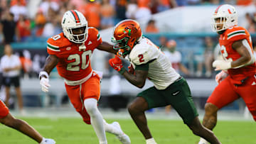Sep 7, 2024; Miami Gardens, Florida, USA; Florida A&M Rattlers wide receiver Jamari Gassett (2) runs with the football against Miami Hurricanes defensive back Zaquan Patterson (20) during the second quarter at Hard Rock Stadium. Mandatory Credit: Sam Navarro-Imagn Images