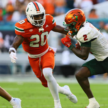 Sep 7, 2024; Miami Gardens, Florida, USA; Florida A&M Rattlers wide receiver Jamari Gassett (2) runs with the football against Miami Hurricanes defensive back Zaquan Patterson (20) during the second quarter at Hard Rock Stadium. Mandatory Credit: Sam Navarro-Imagn Images