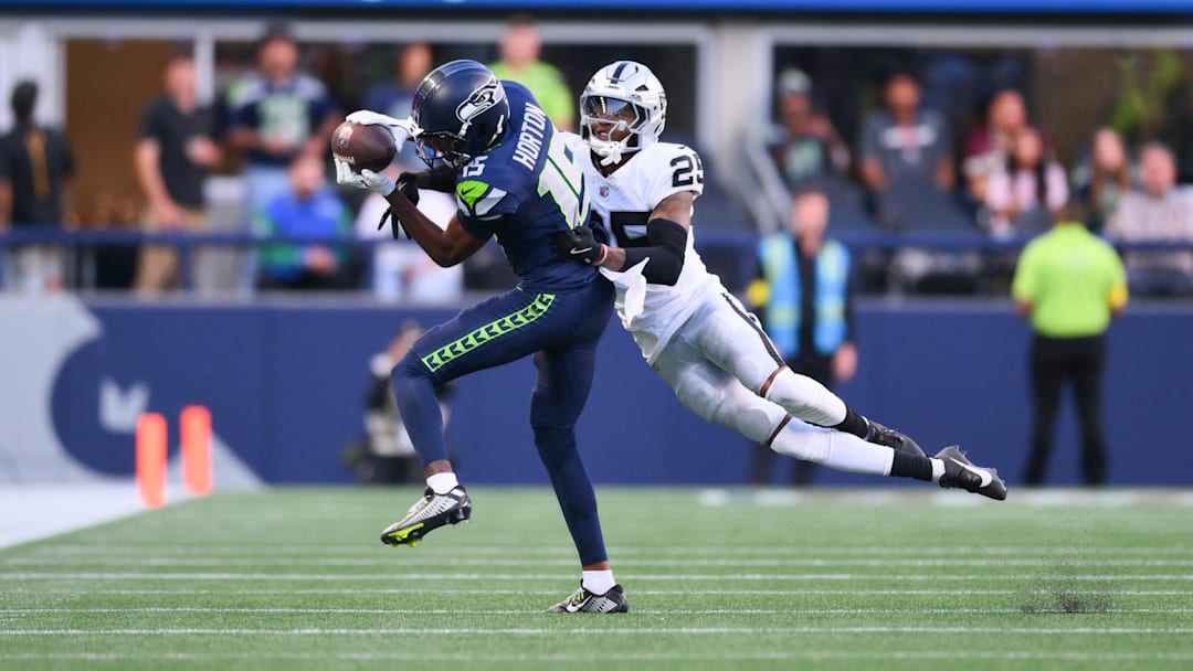Seattle Seahawks wide receiver Tory Horton (15) catches a pass while covered by Las Vegas Raiders cornerback Decamerion Richardson (25) during the first half at Lumen Field. 