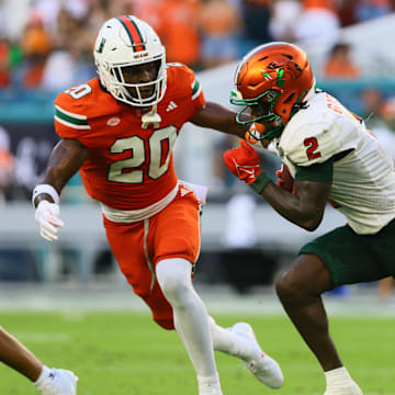 Sep 7, 2024; Miami Gardens, Florida, USA; Florida A&M Rattlers wide receiver Jamari Gassett (2) runs with the football against Miami Hurricanes defensive back Zaquan Patterson (20) during the second quarter at Hard Rock Stadium. Mandatory Credit: Sam Navarro-Imagn Images