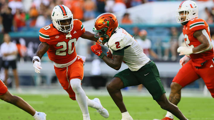 Sep 7, 2024; Miami Gardens, Florida, USA; Florida A&M Rattlers wide receiver Jamari Gassett (2) runs with the football against Miami Hurricanes defensive back Zaquan Patterson (20) during the second quarter at Hard Rock Stadium. Mandatory Credit: Sam Navarro-Imagn Images