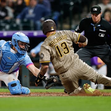 May 9, 2025; Denver, Colorado, USA; Colorado Rockies catcher Hunter Goodman (15) attempts to tag out San Diego Padres third baseman Manny Machado (13) in the sixth inning at Coors Field. Mandatory Credit: Isaiah J. Downing-Imagn Images