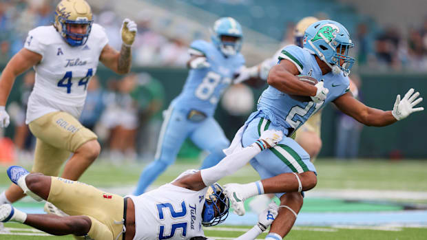 Tulsa Golden Hurricane safety Jaise Oliver (25) tries to tackler Tulane Green Wave running back Makhi Hughes (21)