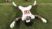 Oklahoma defensive lineman Danny Okoye makes grass angels on the field after the Sooners defeated Alabama.