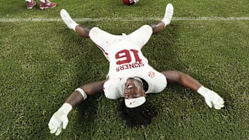 Oklahoma defensive lineman Danny Okoye makes grass angels on the field after the Sooners defeated Alabama.