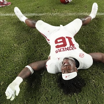 Oklahoma defensive lineman Danny Okoye makes grass angels on the field after the Sooners defeated Alabama.