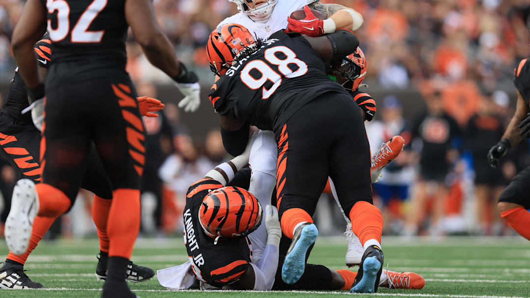 Dec 28, 2025; Cincinnati, Ohio, USA; Cincinnati Bengals defensive tackle T.J. Slaton Jr. (98) and linebacker Demetrius Knight Jr. (44) tackle Arizona Cardinals tight end Trey McBride (85) during the second half at Paycor Stadium. Mandatory Credit: Katie Stratman-Imagn Images