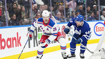 Chris Kreider  controlling the puck against Leafs defense Morgan Rielly.