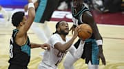 Dec 3, 2025; Cleveland, Ohio, USA; Cleveland Cavaliers guard Darius Garland (10) looks to shoot between Portland Trail Blazers forward Toumani Camara (33) and guard Sidy Cissoko (91) in the fourth quarter at Rocket Arena. Mandatory Credit: David Richard-Imagn Images