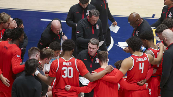 Jan 7, 2025; Morgantown, West Virginia, USA; Arizona Wildcats head coach Tommy Lloyd talks to his team during a timeout during the second half against the West Virginia Mountaineers at WVU Coliseum. Mandatory Credit: Ben Queen-Imagn Images