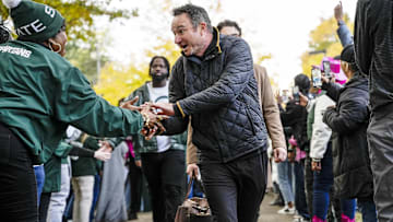 Oct 25, 2025; East Lansing, Michigan, USA; Michigan State head coach Jonathan Smith shakes hands with a fan during the Spartan Walk to Spartan Stadium. Mandatory Credit: Brendan Mullin-Imagn Images