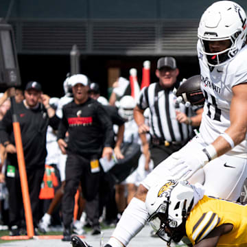 Towson Tigers defensive lineman Mazio Randall (9) tackles Cincinnati Bearcats tight end Joe Royer (11) in the second quarter of the College Football game at Nippert Stadium in Cincinnati on Saturday, Aug. 31, 2024.