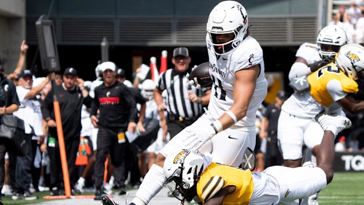 Towson Tigers defensive lineman Mazio Randall (9) tackles Cincinnati Bearcats tight end Joe Royer (11) in the second quarter of the College Football game at Nippert Stadium in Cincinnati on Saturday, Aug. 31, 2024.