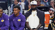 Oct 5, 2025; San Francisco, California, USA: Los Angeles Lakers guard Bronny James (9) and forward LeBron James (23), wearing a Los Angeles Dodgers cap, watch the action against the Golden State Warriors in the first quarter at Chase Center. Mandatory Credit: David Gonzales-Imagn Images
