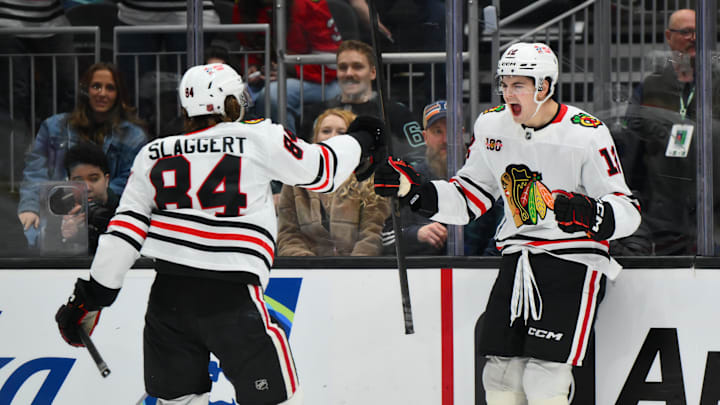 Apr 4, 2026; Seattle, Washington, USA; Chicago Blackhawks center Sacha Boisvert (12) celebrates with left wing Landon Slaggert (84) after scoring his first career NHL goal during the third against the Seattle Kraken period at Climate Pledge Arena. Mandatory Credit: Steven Bisig-Imagn Images