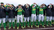 Oregon baseball players flash the “O” to fans after the Ducks beat the Toledo Rockets at PK Park in Eugene Saturday, Feb. 15, 2025.