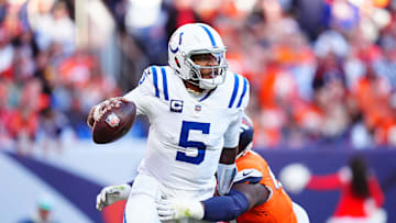 Dec 15, 2024; Denver, Colorado, USA; Indianapolis Colts quarterback Anthony Richardson (5) runs past the tackle of Denver Broncos defensive tackle Malcolm Roach (97) in the second quarter at Empower Field at Mile High. Mandatory Credit: Ron Chenoy-Imagn Images