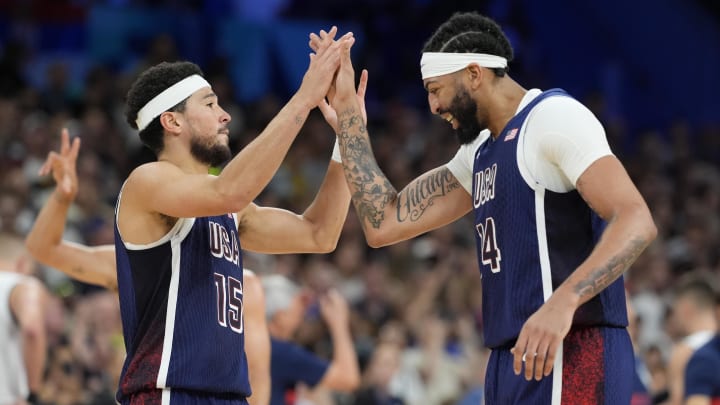 Jul 28, 2024; Villeneuve-d'Ascq, France; United States guard Devin Booker (15) and center Anthony Davis (14) celebrate in the fourth quarter against Serbia during the Paris 2024 Olympic Summer Games at Stade Pierre-Mauroy. Mandatory Credit: John David Mercer-USA TODAY Sports