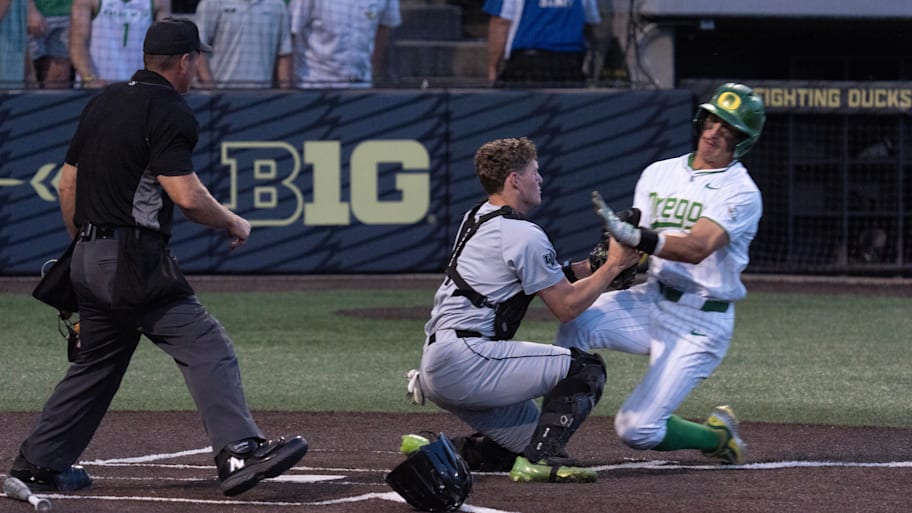 Oregon’s Aroz, right, slides into Utah Valley catcher Strong at the plate in the eighth inning of the Eugene NCAA Regional at PK Park. | Chris Pietsch/The Register-Guard / USA TODAY NETWORK via Imagn Images