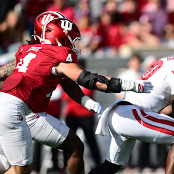 Nov 15, 2025; Bloomington, Indiana, USA;  Wisconsin Badgers running back Gideon Ituka (10) runs the ball past Indiana Hoosiers linebacker Aiden Fisher (4) during the second quarter at Memorial Stadium.