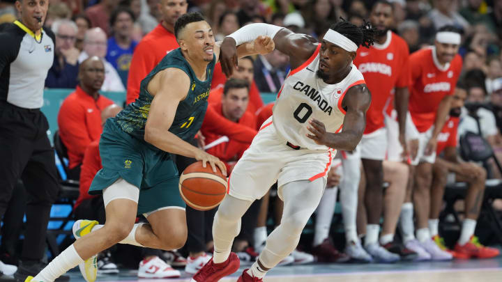 Jul 30, 2024; Villeneuve-d'Ascq, France; Australia point guard Dante Exum (11) in action against Canada guard Luguentz Dort (0) in a men's group stage basketball match during the Paris 2024 Olympic Summer Games at Stade Pierre-Mauroy. Mandatory Credit: John David Mercer-USA TODAY Sports