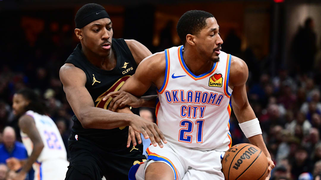 Jan 19, 2026; Cleveland, Ohio, USA; Oklahoma City Thunder guard Aaron Wiggins (21) controls the ball in front of Cleveland Cavaliers forward Nae'qwan Tomlin (35) during the second half at Rocket Arena. Mandatory Credit: Ken Blaze-Imagn Images