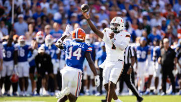 Aug 31, 2024; Gainesville, Florida, USA; Miami Hurricanes quarterback Cam Ward (1) throws the ball under pressure from Florida Gators defensive back Jordan Castell (14) during the first half at Ben Hill Griffin Stadium. Mandatory Credit: Matt Pendleton-USA TODAY Sports