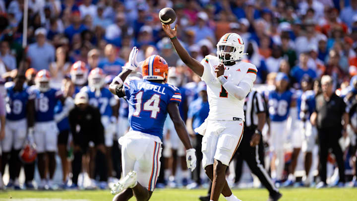 Aug 31, 2024; Gainesville, Florida, USA; Miami Hurricanes quarterback Cam Ward (1) throws the ball under pressure from Florida Gators defensive back Jordan Castell (14) during the first half at Ben Hill Griffin Stadium. Mandatory Credit: Matt Pendleton-Imagn Images