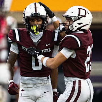 Dowling Catholic's Jordan Watson (0) and Jeremiah Roberson (21) celebrate after a stop on defense during the semifinal round of the Iowa high school football state championships at the UNI-Dome on Friday, Nov. 14, 2025, in Cedar Falls.
