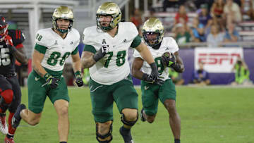 Nov 1, 2024; Boca Raton, Florida, USA;  South Florida Bulls offensive lineman Jack Wilty (78) and tight end Payten Singletary (88) block for running back Kelley Joiner (8) during the second half against the Florida Atlantic Owls at FAU Stadium. Credit: Reinhold Matay-Imagn Images