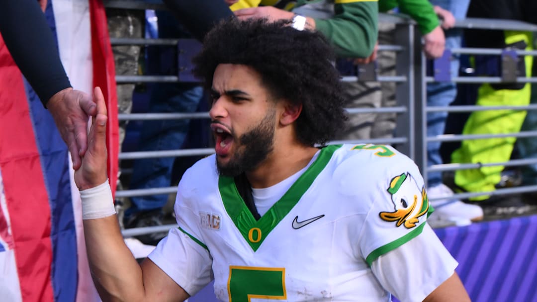Nov 29, 2025; Seattle, Washington, USA; Oregon Ducks quarterback Dante Moore (5) celebrates with fans after Oregon defeated the Washington Huskies at Husky Stadium. Mandatory Credit: Steven Bisig-Imagn Images Nov 29, 2025; Seattle, Washington, USA; Oregon Ducks quarterback Dante Moore (5) celebrates with fans after Oregon defeated the Washington Huskies at Husky Stadium. Mandatory Credit: Steven Bisig-Imagn Images