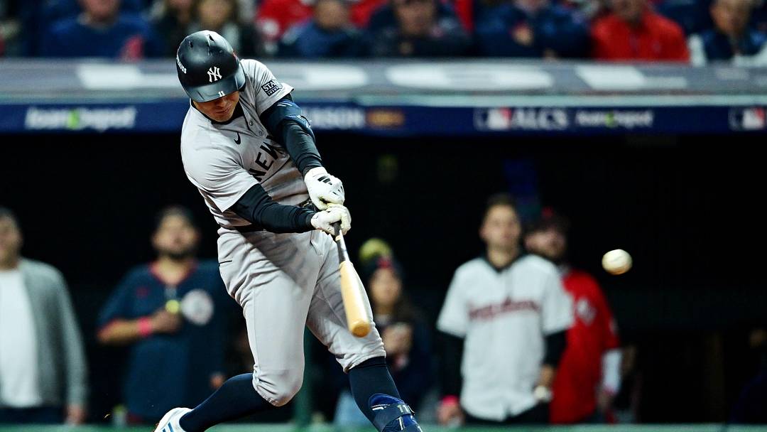 Oct 19, 2024; Cleveland, Ohio, USA; New York Yankees shortstop Anthony Volpe (11) hits single during the fifth inning against the Cleveland Guardians during game five of the ALCS for the 2024 MLB playoffs at Progressive Field. Mandatory Credit: David Dermer-Imagn Images