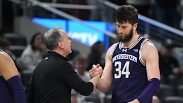 Mar 13, 2025; Indianapolis, IN, USA; Northwestern Wildcats head coach Chris Collins greets Northwestern Wildcats center Matthew Nicholson (34) as he checks out of the game during the second half against the Wisconsin Badgers at Gainbridge Fieldhouse. Mandatory Credit: Robert Goddin-Imagn Images
