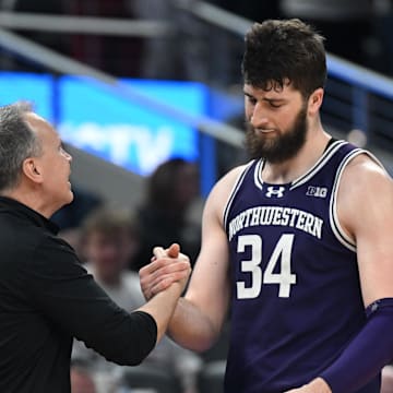 Mar 13, 2025; Indianapolis, IN, USA; Northwestern Wildcats head coach Chris Collins greets Northwestern Wildcats center Matthew Nicholson (34) as he checks out of the game during the second half against the Wisconsin Badgers at Gainbridge Fieldhouse. Mandatory Credit: Robert Goddin-Imagn Images