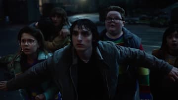 (L to R) Winona Ryder as Joyce Byers, Finn Wolfhard as Mike Wheeler, and Jake Connelly as Derek in Stranger Things season 5
