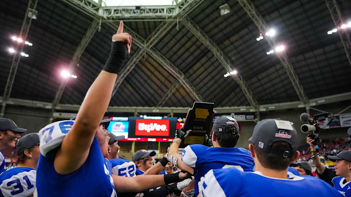 Remsen St. Mary's team celebrate with the trophy after winning the eight-man playoff finals Thursday, Nov. 17, 2022, at the UNI-Dome in Cedar Falls. The Hawks defeated the Warriors, 38-16.