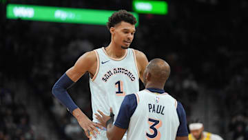 Nov 27, 2024; San Antonio, Texas, USA;  San Antonio Spurs center Victor Wembanyama (1) talks with guard Chris Paul (3) in the second half against the Los Angeles Lakers at Frost Bank Center. Mandatory Credit: Daniel Dunn-Imagn Images