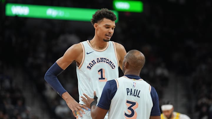 Nov 27, 2024; San Antonio, Texas, USA;  San Antonio Spurs center Victor Wembanyama (1) talks with guard Chris Paul (3) in the second half against the Los Angeles Lakers at Frost Bank Center. Mandatory Credit: Daniel Dunn-Imagn Images