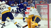 Oct 10, 2023; Tampa, Florida, USA;Tampa Bay Lightning right wing Nikita Kucherov (86) shoots as Nashville Predators goaltender Juuse Saros (74) defends during the first period at Amalie Arena. Mandatory Credit: Kim Klement Neitzel-Imagn Images
