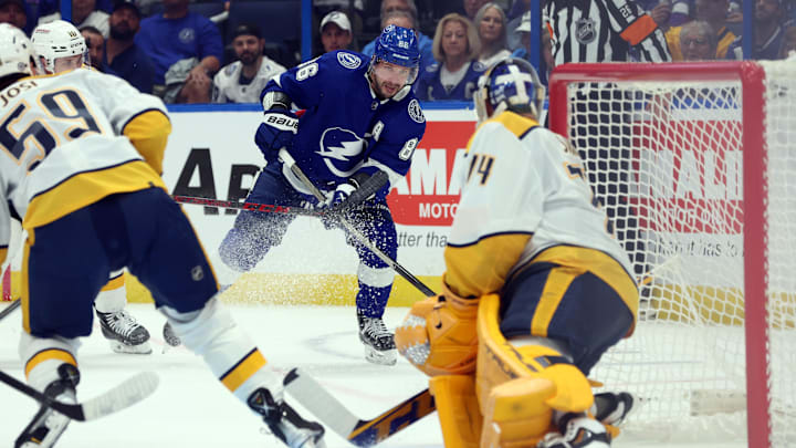 Oct 10, 2023; Tampa, Florida, USA;Tampa Bay Lightning right wing Nikita Kucherov (86) shoots as Nashville Predators goaltender Juuse Saros (74) defends during the first period at Amalie Arena. Mandatory Credit: Kim Klement Neitzel-Imagn Images