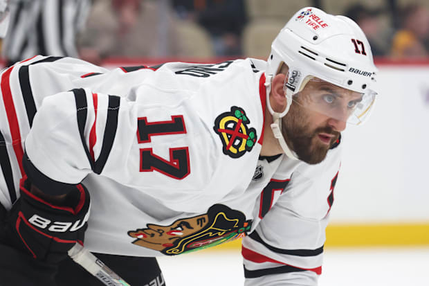 Hockey player in white uniform waits for face-of